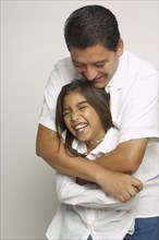 Hispanic father and daughter hugging