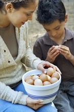 Hispanic mother and son with bowl of eggs