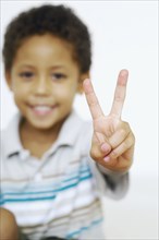 Mixed race boy gesturing the peace sign