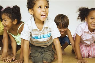 Multi-ethnic children kneeling and smiling