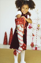 Mixed race girl reaching into Christmas stocking