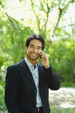 Hispanic businessman talking on cell phone outdoors