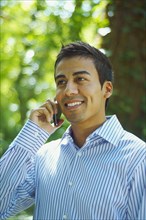 Hispanic man talking on cell phone outdoors