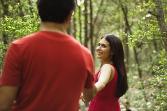 Hispanic couple holding hands and walking outdoors