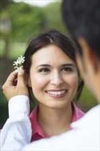 Hispanic husband putting flower behind wife's ear