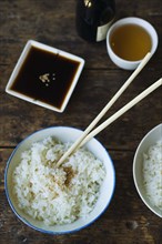 Bowl of rice and chopsticks with sauces