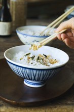 Person eating rice with chopsticks
