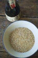 Bottle of sake and bowl of sesame seeds