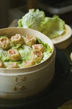 Asian dumplings in steamer with cabbage