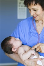 Nurse holding baby in doctor's office