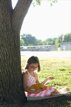 Hispanic girl reading in park