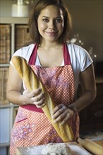 Mixed race woman baking bread in kitchen