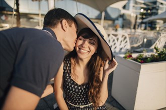 Caucasian man kissing woman on cheek