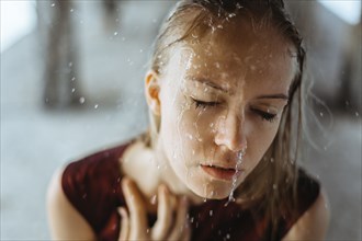 Water splashing on face of Caucasian girl