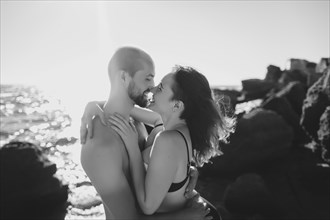 Caucasian couple hugging on sunny beach