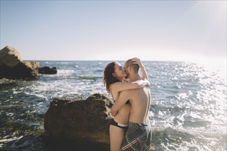 Caucasian couple hugging in ocean