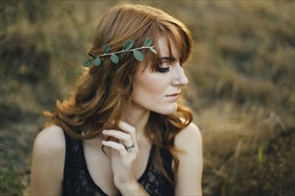 Pensive Caucasian woman with leaves in hair