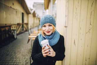 Portrait of smiling Caucasian woman holding coffee cup
