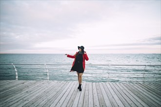Portrait of carefree Caucasian woman standing on boardwalk