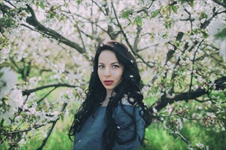Caucasian woman posing near flowering tree