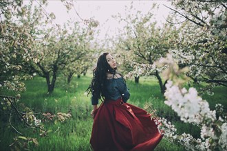 Caucasian woman walking near flowering trees