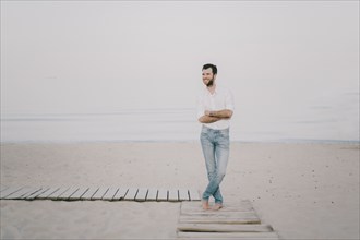 Caucasian man standing on boardwalk at beach