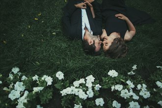 Caucasian couple laying in grass laughing
