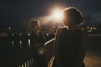Caucasian man and woman at waterfront at night