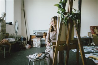 Caucasian woman painting in studio