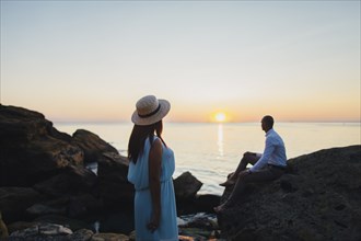 Caucasian couple admiring scenic view of ocean sunset