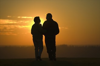 Hispanic couple standing outdoors at sunset