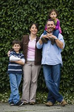 Family posing near hedge
