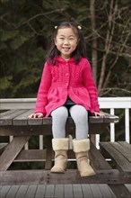 Korean girl sitting on picnic bench