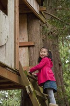 Korean girl climbing into tree house