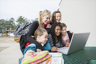 School friends looking at laptop
