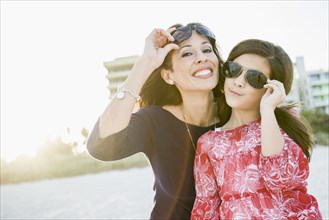 Hispanic mother and daughter wearing sunglasses