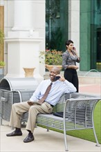 Business people talking on cell phones outdoors