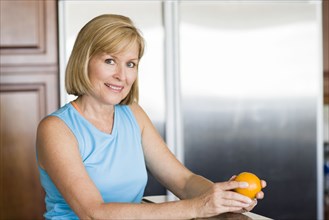 Caucasian woman peeling fruit in kitchen