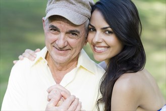 Hispanic father and daughter smiling outdoors