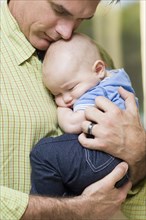 Caucasian father holding baby boy
