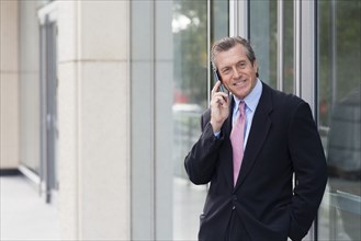 Caucasian businessman on cell phone outside building