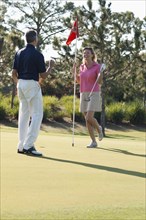 Caucasian couple playing golf on course