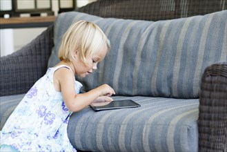 Caucasian girl using digital tablet on sofa