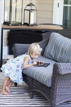 Caucasian girl using digital tablet on sofa