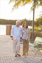 Older Caucasian couple holding hands outdoors