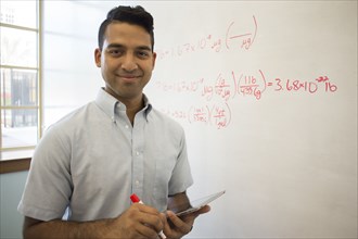Asian businessman using digital tablet at whiteboard