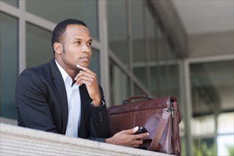Black businessman thinking outside building