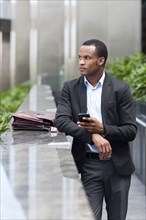 Black businessman using cell phone outdoors