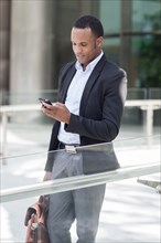 Black businessman using cell phone outdoors