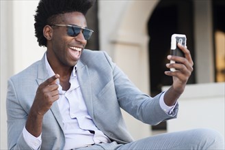 Black businessman taking selfie outside building